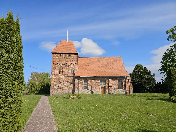 Zabytkowy ceglany kościół z dachem pokrytym dachówką ceramiczną